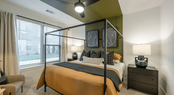 A bedroom with a large bed and a chair.